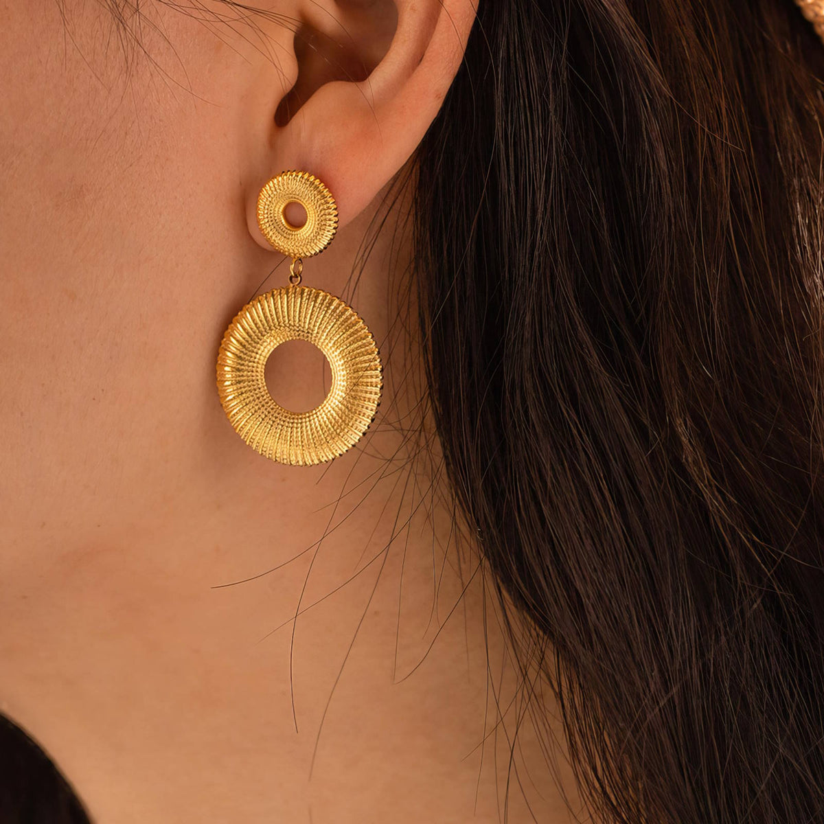 Textured Double Circle Drop Earrings: worn, close-up at the ear, gold tone